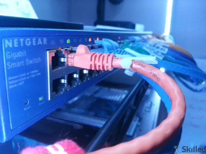 Close-up of color-coded cables plugged into the Netgear core switch