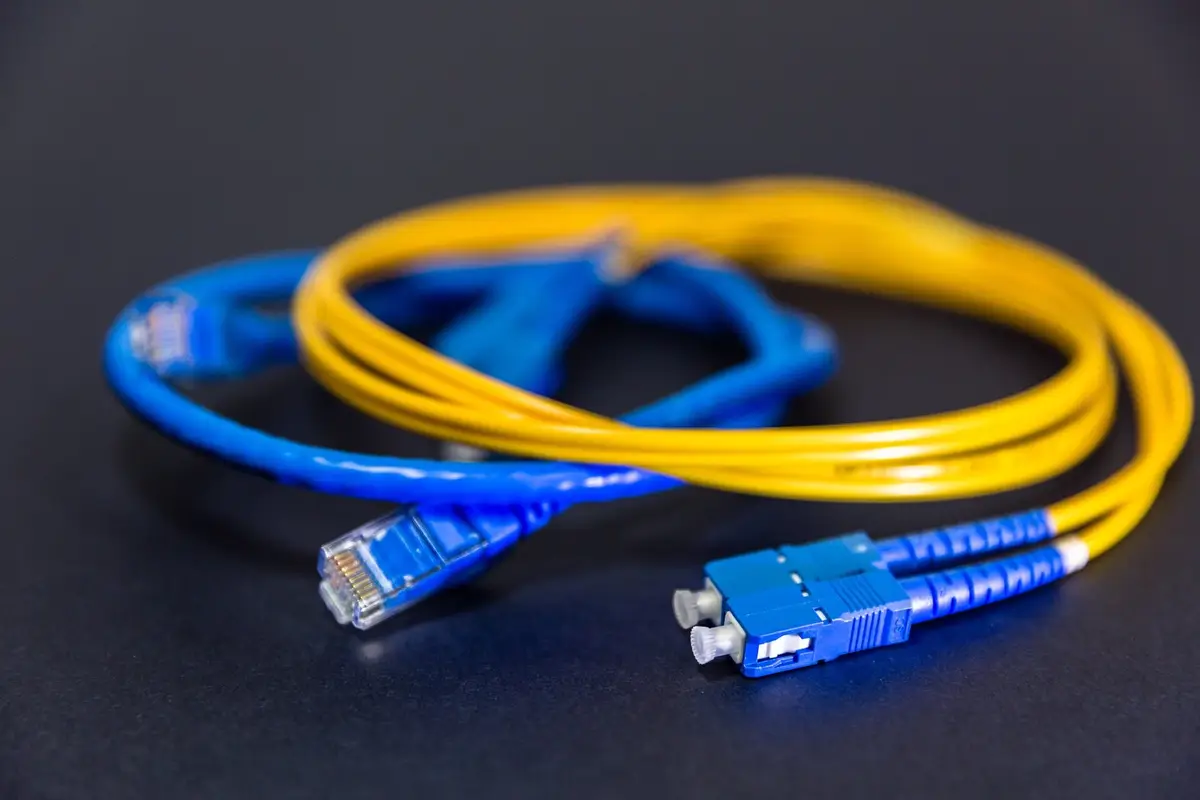 Coiled yellow fiber-optic cable with blue connectors